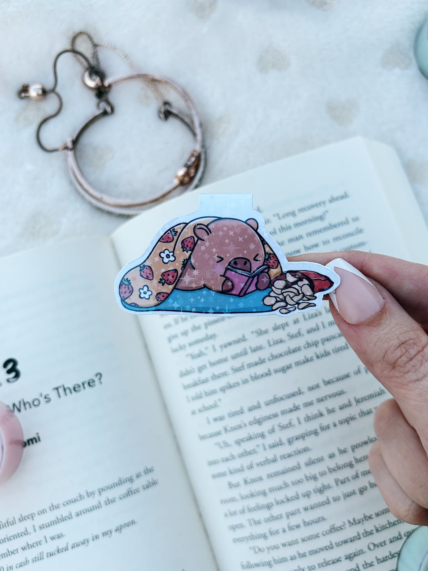 Capybara laying down and reading magnetic bookmark
